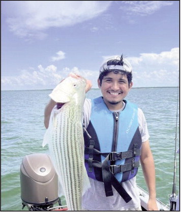 (ABOVE) Issac L. with striped bass caught at Lake Texoma. Share your photos with us!