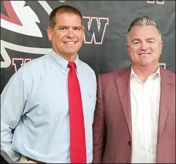 At Clint Benway and Superintendent Kyle Hitlerbran are all smiles in front of the Watonga Eagle in the board room. Benway has been named head football coach for the upcoming school year. Photo by Connie Burcham