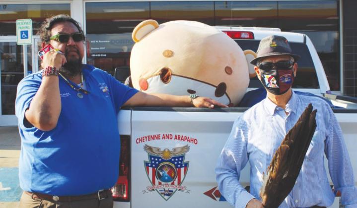 Alan Fletcher (left) and Larry Roman Nose pose with Bearsun at the Domino convenience store in Watonga on Monday, Sept. 6. Bearsun is walking across the country to raise money for charity.