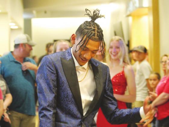 Prom King Devon Wilson dances down the walkway at the Lucky Star Convention Center to start the promenade on Saturday, April 23.