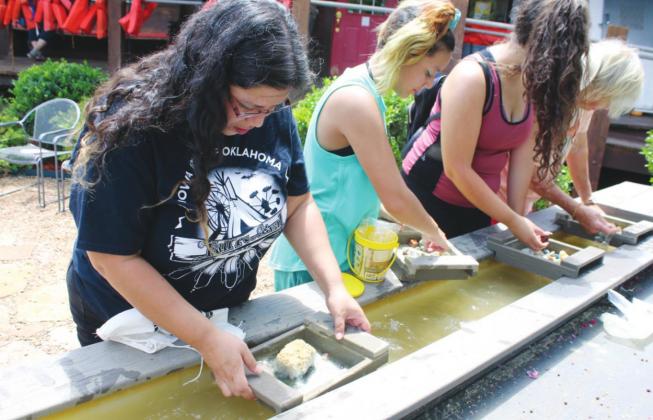 (Above) Sonora WhiteHorse, Sunny Toehay, Cynthia Skinner and Karan Brunken work the sluice box panning for gems at Roman Nose General Store. The gem panning is a newly added activity. Connie Burcham | Watonga Republican