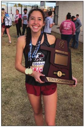 Riley Coleman holding the state champion trophy that the Watonga cross country team won.