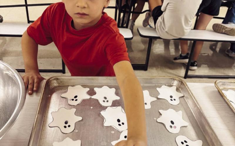 Right: Shannon Russell ran a new PR of 19:18, finished 82nd against 130+ incredibly strong runners, a fast course and tough competition made for an exciting race. Below: Geary 1st and 2nd graders Having a Spook-Tacular time learning how to grow ghost salt crystals. and Geary Mini Cheer
