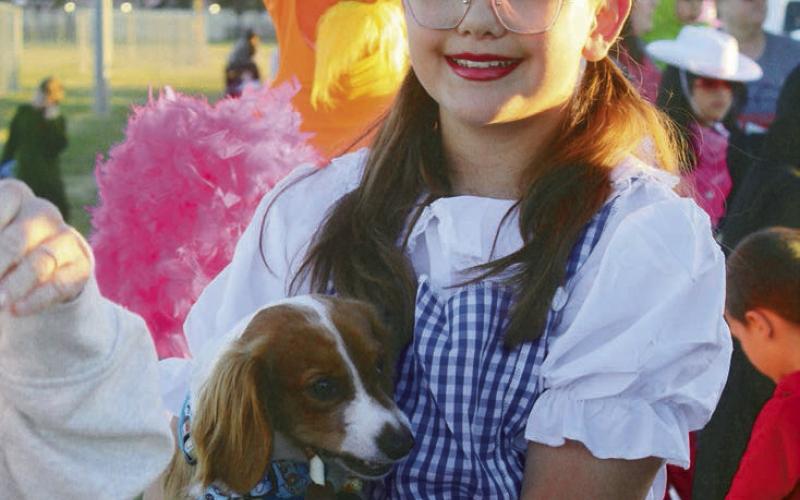 Dorothy brought her own dog in place of Toto. (BELOW LEFT) Ember Flatt was not quite sure what to make of her first Halloween as a walker. (BELOW) A beautiful fairy stopped for a moment to discuss gossamer wings.