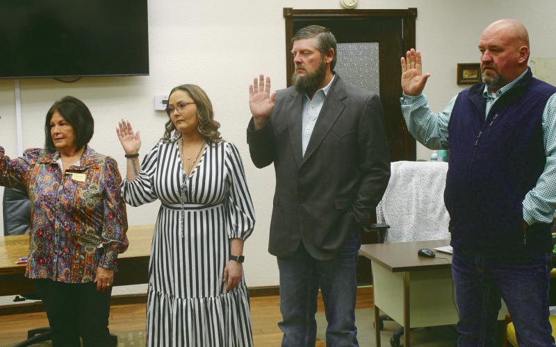 Shown being sworn in (L-R) Christy Matli, court clerk, Heather Spangler-Sawayer, county clerk, Brandon Schultz, county commissiner and Travis Daugherty, sheriff. PHOTO BY CONNIE BURCHAM