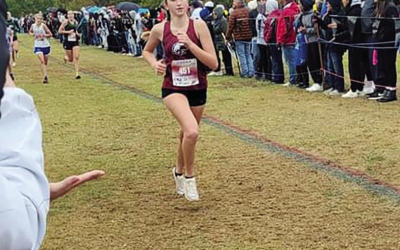Saturday on a cold wet cross country course in Edmond, Reese Coleman (Above)placed fifth in the state meet. Brayden Cowan (Lower left)won the state championship and the boys’ team (top two photos) placed 12th.