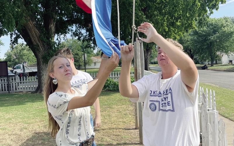 ABOVE LEFT) Jaidon Turney and Parker Davidson raise the American and Oklahoma state flags during a Falg Day ceremony aat the T.B. Ferguson Home on Saturday. The event was a solumn celebration of the flags, their meanings and the value they add to life in these United States.