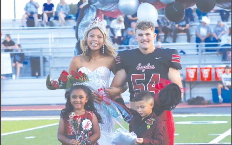 Coronation of the homecoming court Friday night in Watonga crowned Julien Roman Nose as homecoming queen and Kale Smith as homecoming king. The junior court members shown are Caidence Hartfield and Drayton Flynn. (Photo provided by Piper Gallagher)