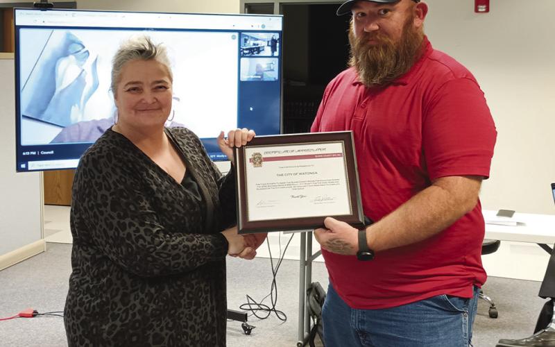 City Manager Karrie Little accepts a certificate of appreciation for the city from John Morris, a principal of the Bikes and BBQ event.