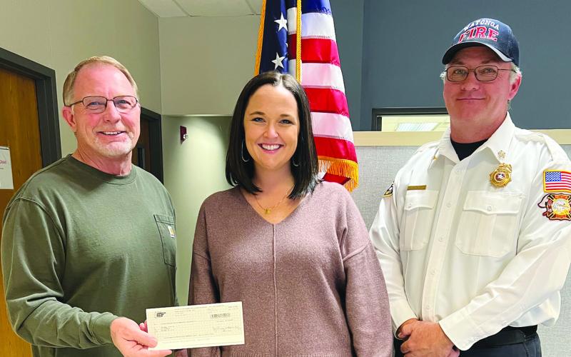 Watonga Mayor Bill Seitter (L) accepts a check from PSO representative Kristi Sproul as Fire Chief Robert Daughter(R) looks on