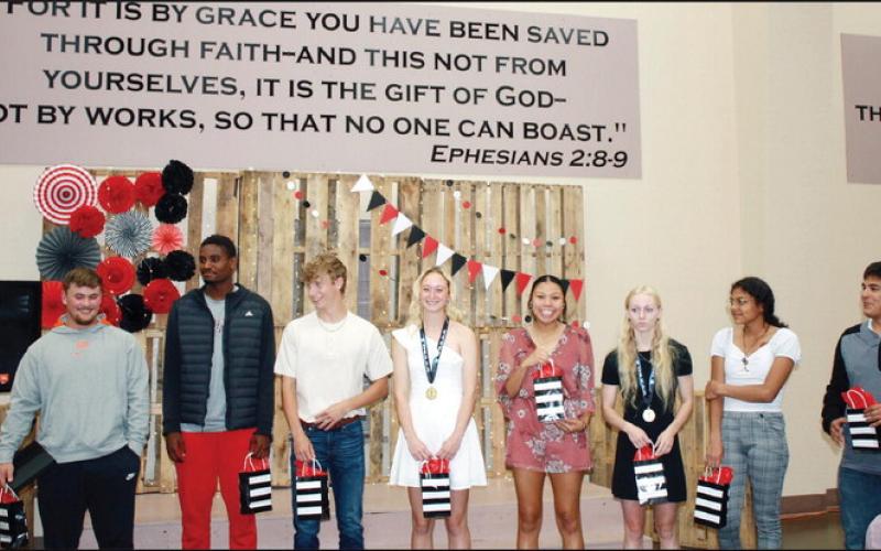 Above:Watonga Eagle track team senior members pose with gift bags atthe end of the awards ceremony Below; Lady Eagle track team members show off the hardware they brought home from state championships