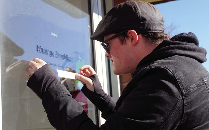 Gunnar Larson, a student at Chisholm Trail Technology Center, applies new door grahics to the offices of the Watonga Republican. After 76 years downtown, the paper has relocated to North Harmon Avenue.