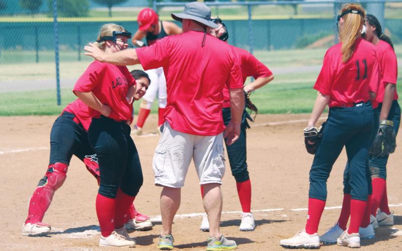 (Above) Geary High School varsity fast-pitch first-year head coach Rick Scott talks with his Lady Bison infielders on Tuesday, June 16 during a Hinton Summer League softball scrimmage against Navajo High School. The Lady Bison took the field for live-action softball for the first time this summer at the Kiwanis Sports Complex in Hinton. Photos by Andrew Salmi The Geary Star