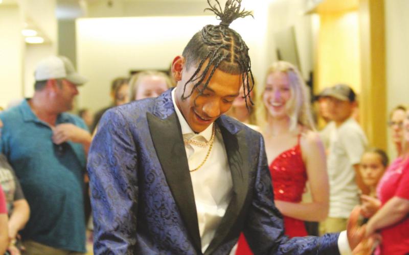 Prom King Devon Wilson dances down the walkway at the Lucky Star Convention Center to start the promenade on Saturday, April 23.