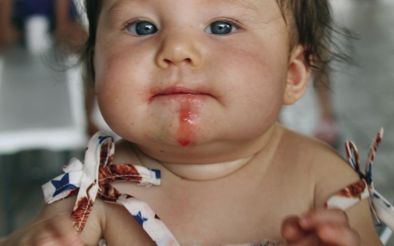 This little cutie was having all the fun the law allowed during the Fourth of July celebration at Huff Lorang park. She was eating a colored ice cup, but some escaped and dripped down her happy little chin.