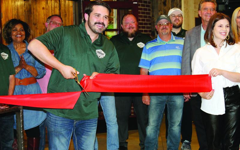 Owner J.P. Wilson is all smiles May 23 as he cuts the ribbon at the grand opening of the Lookout Kitchen at Roman Nose State Park.