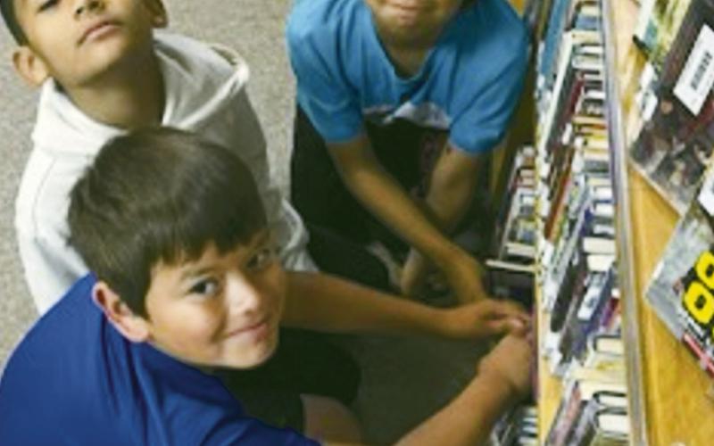 ABOVE AT LEFT Fourth graders examine library books during their class unit on typefaces.