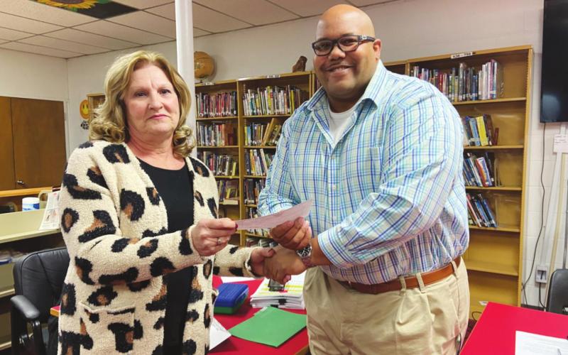 Linda Austin presents Geary Superintendent Sean Buchanan a $221,928 check made out to Geary Public Schools, courtesy of the Austin Family Trust and the estate of Geary graduate and local farmer Frank Austin. She hopes the donation will help Geary students pursue higher or technical education.