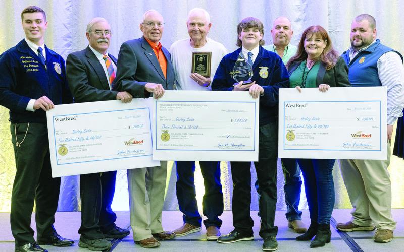 Destry Swaim, (center) won so much at the Oklahoma Junior Wheat Show he had to have help holding all the checks for the photo opp. Destry is a member of the Okeene FFA.
