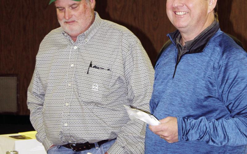 At right, auctioneer Chris Ridenhour jokes with Todd Lafferty of Wheeler Brothers prior to the start of the annual LIons Club cake auction.