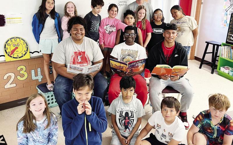 (ABOVE) The third grade class at Geary Elementary was visited by three high school English students and basketball players (Carlos Cardoso, Jaiden Woods and Sergio Pineda). These three students wanted to share their love for reading and encourage the students of Geary Elementary to continue reading. (BELOW) Kindergarteners signed letters of intent for first grade.
