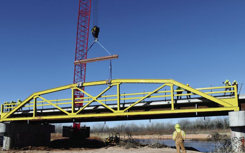 The first of the refurbished spans on the famous ‘Pony Bridge’ on the road between U.S. 281 and Hinton was lowered into place Jan. 11. The restoration of the bridge is progressing on schedule for a spring reopening. Photo by Richard Stephens