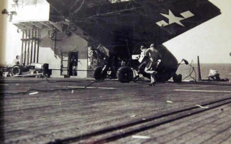 Coot Nelson’s first landing on an aircraft carrier was nearly his last. His signal man brought him in too high and his plane missed the grab cables. Luckily, webbing on the lip of the ship caught the plane before it went over the side.