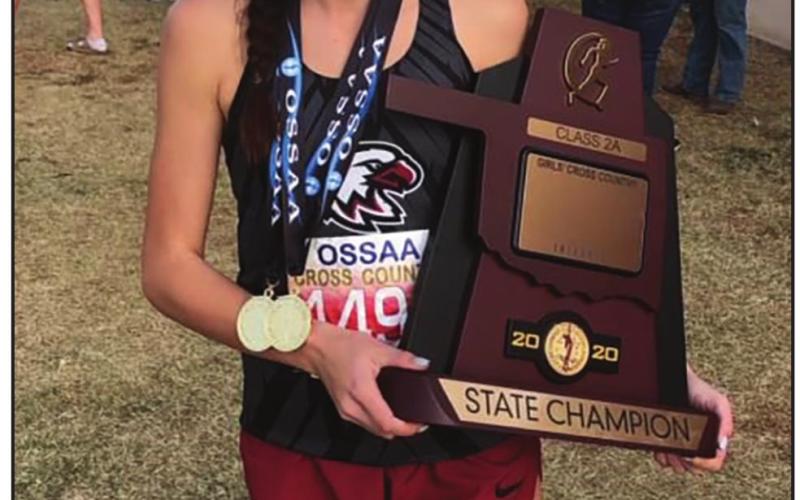 Riley Coleman holding the state champion trophy that the Watonga cross country team won.