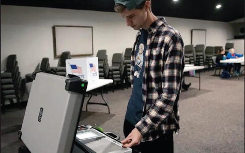 University of Oklahoma student Blake Hiebert, 22, sends his ballot into a machine at his Norman polling station after voting. Less than 10% of Oklahoma voters 30 and under participated in that election. Whitney Bryen/Oklahoma Watch