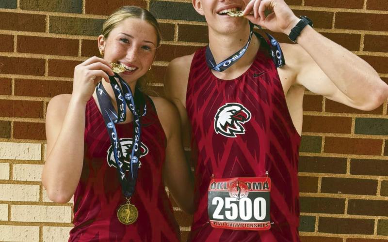 Reese Coleman (L)and Brayden Cowan (R) ham it up with their state championship gold medals after the state cross country meet Saturday. Cowan had previously won a gold in track while Coleman was a runnerup.