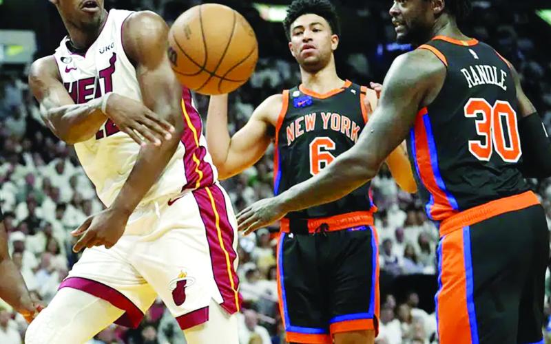 Miami Heat forward Jimmy Butler, left, passes the ball as New York Knicks Quentin Grimes (6) and Julius Randle (30) look on during the second half of Game 4 of the NBA basketball Eastern Conference playoff semifinal, Monday, May 8, 2023, in Miami. (AP Photo/Lynne Sladky)