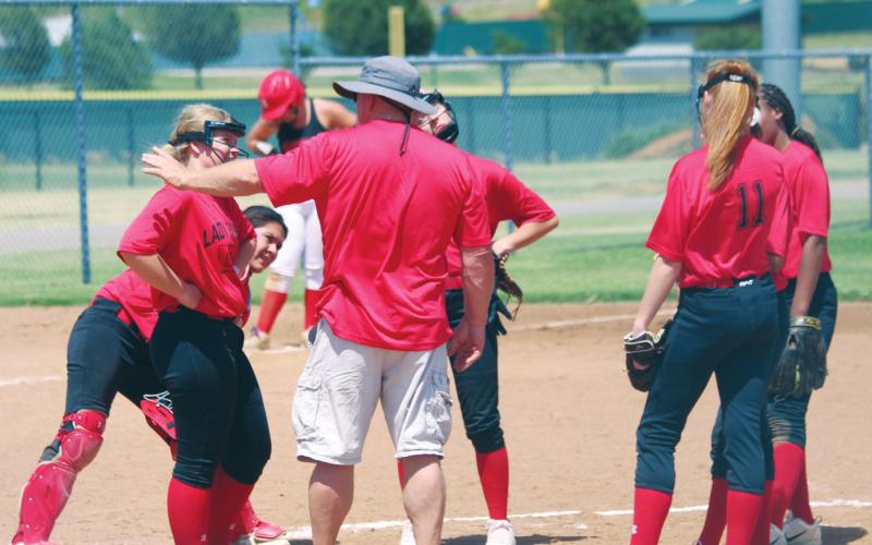 (Above) Geary High School varsity fast-pitch first-year head coach Rick Scott talks with his Lady Bison infielders on Tuesday, June 16 during a Hinton Summer League softball scrimmage against Navajo High School. Andrew Salmi The Geary Star