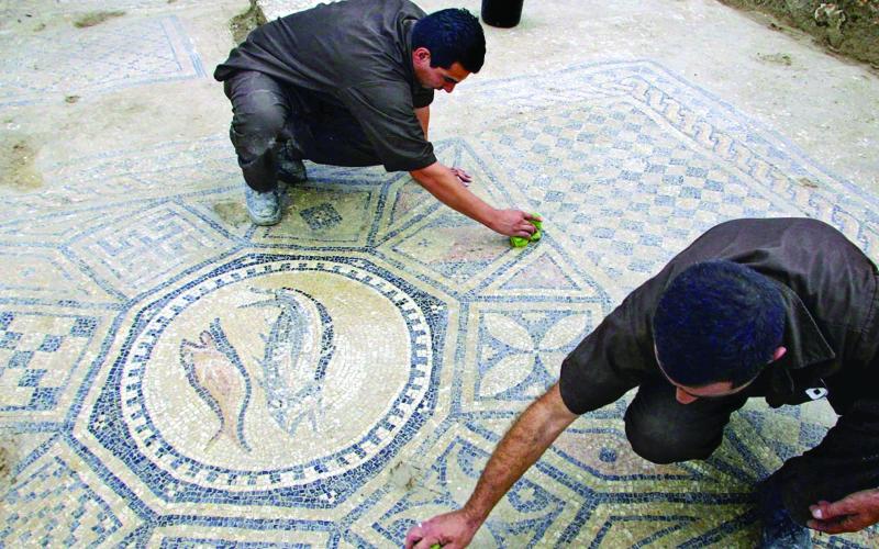 PRISONERS WORK AT A NEARLY 1,800-YEAR-OLD DECORATED FLOOR FROM AN EARLY CHRISTIAN PRAYER HALL DISCOVERED BY ISRAELI ARCHEOLOGISTS. (AP PHOTO/ARIEL SCHALIT, FILE)