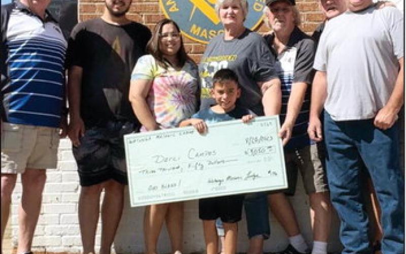 Left to right: Darrel Parker (Mason Secretary), Kohl Campos, Darci Campos, Jaxon Campos, Margaret Parham, Kelly Logan (Mason Worshipful Master), Damon Jones (Mason Treasurer), Brett Parker (Mason Senior Warden). The Masons were presenting the check to the Campos family as part of their mission to assist citizens.