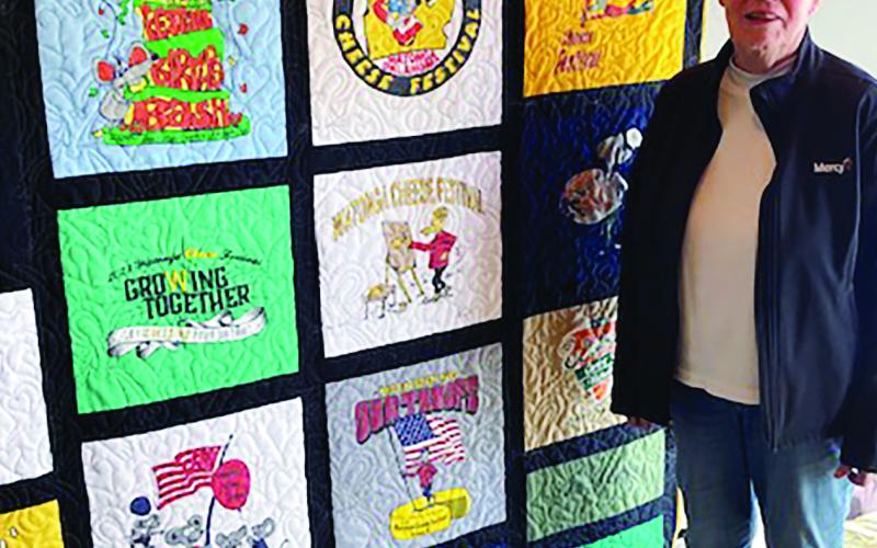The winners of the Cheese Festival T-shirt quilt raffle were Bob Geshe, who purchased the ticket, and Karen Beirs shown above with the quilt shortly after the drawing. The raffle was a fundraiser for the Cheyenne Quilt Guild. The quilt is made from t-shirts from many previous Cheese Festivals.
