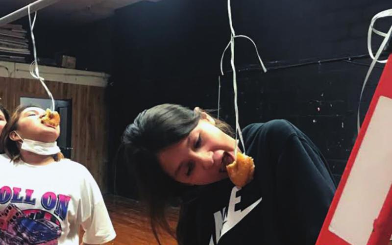 Randi Upchego (right) and Carmen Littleraven (left) doing the donut challenge during Spirit Week activities. (Photo provided)
