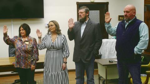 Shown being sworn in (L-R) Christy Matli, court clerk, Heather Spangler-Sawayer, county clerk, Brandon Schultz, county commissiner and Travis Daugherty, sheriff. PHOTO BY CONNIE BURCHAM