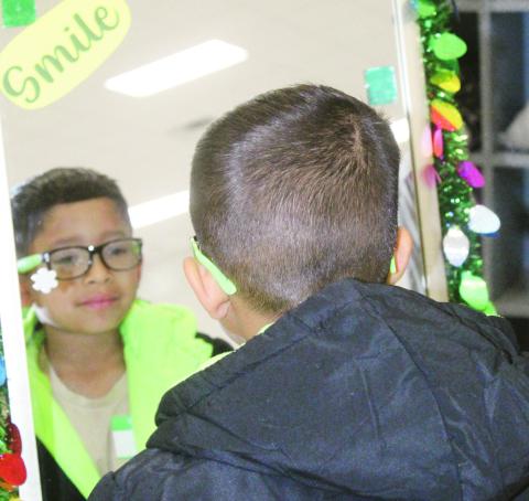 A Watonga Elementary School student admires himself in the mirror after selecting a coat with the help of a ‘personal shopper’ during the school’s Operation Warm, where every child recieved a coat. PHOTO by Connie Burcham