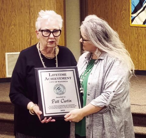 Patt Ward Curtin (L) receives a lifetime achievement award plaque Feb. 29 from Watonga CIty Manager Karrie Beth Little. Curtin is known as an educator and thespian whose dedication to the LIberty Theatre and play production brought the theater group and the town to prominence and won several national awards.