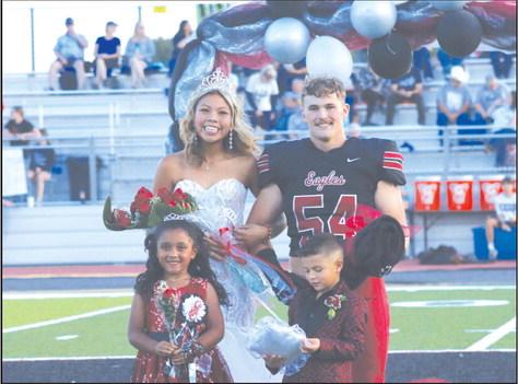 Coronation of the homecoming court Friday night in Watonga crowned Julien Roman Nose as homecoming queen and Kale Smith as homecoming king. The junior court members shown are Caidence Hartfield and Drayton Flynn. (Photo provided by Piper Gallagher)