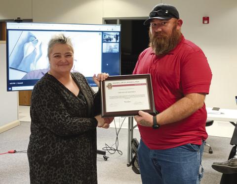 City Manager Karrie Little accepts a certificate of appreciation for the city from John Morris, a principal of the Bikes and BBQ event.