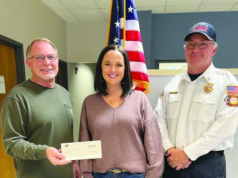 Watonga Mayor Bill Seitter (L) accepts a check from PSO representative Kristi Sproul as Fire Chief Robert Daughter(R) looks on