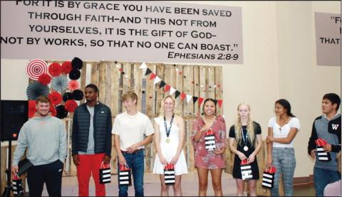 Above:Watonga Eagle track team senior members pose with gift bags atthe end of the awards ceremony Below; Lady Eagle track team members show off the hardware they brought home from state championships