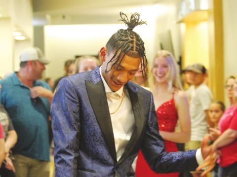 Prom King Devon Wilson dances down the walkway at the Lucky Star Convention Center to start the promenade on Saturday, April 23.