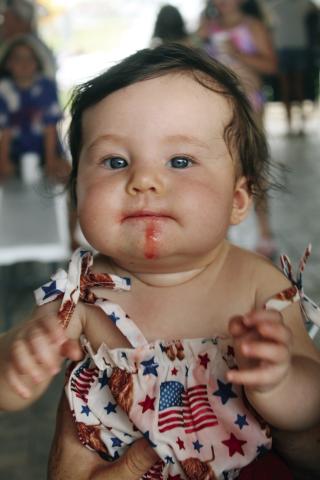 This little cutie was having all the fun the law allowed during the Fourth of July celebration at Huff Lorang park. She was eating a colored ice cup, but some escaped and dripped down her happy little chin.