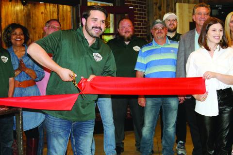 Owner J.P. Wilson is all smiles May 23 as he cuts the ribbon at the grand opening of the Lookout Kitchen at Roman Nose State Park.