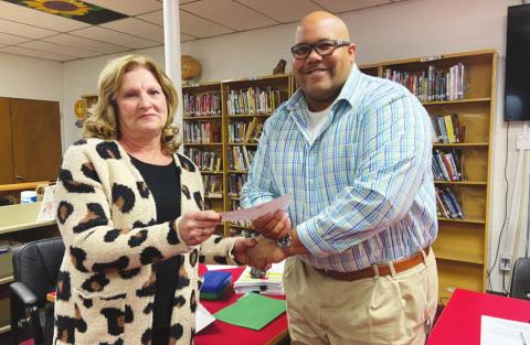 Linda Austin presents Geary Superintendent Sean Buchanan a $221,928 check made out to Geary Public Schools, courtesy of the Austin Family Trust and the estate of Geary graduate and local farmer Frank Austin. She hopes the donation will help Geary students pursue higher or technical education.