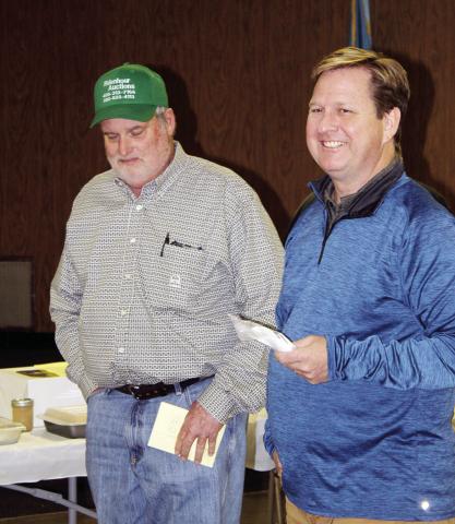 At right, auctioneer Chris Ridenhour jokes with Todd Lafferty of Wheeler Brothers prior to the start of the annual LIons Club cake auction.