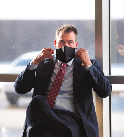 Gov. Kevin Stitt is seen putting on a mask after speaking to reporters at Integris Baptist Medical Center in Oklahoma City on Dec. 14, 2020. Whitney Bryen/Oklahoma Watch Watonga Republican