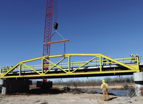 The first of the refurbished spans on the famous ‘Pony Bridge’ on the road between U.S. 281 and Hinton was lowered into place Jan. 11. The restoration of the bridge is progressing on schedule for a spring reopening. Photo by Richard Stephens